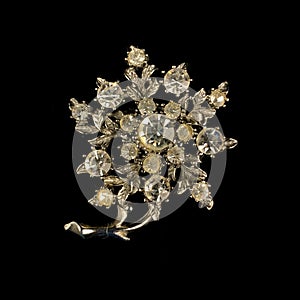 Antique gold brooch with precious stones and crystals in the shape of a flower.