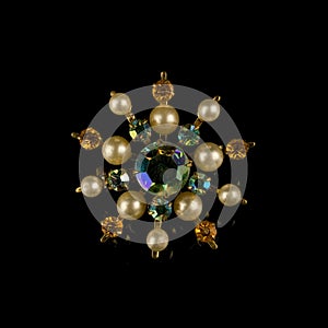 Antique gold brooch with precious stones and crystals in the shape of a flower.