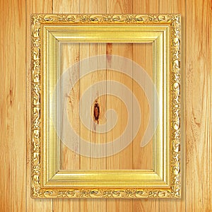 Antique gold frame on wooden wall;. Empty picture frame on woode