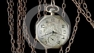 Antique gold pocket watch hanging from a rough rusty chain. Vintage round clock on an aged chain with rusty rough links