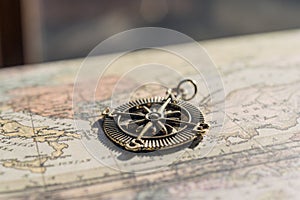 Antique golden compass on a vintage map, travel background