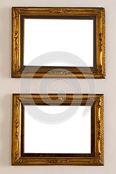 Antique golden frame isolated on white background. Old wooden frame with floral carvings painted with gold paint.
