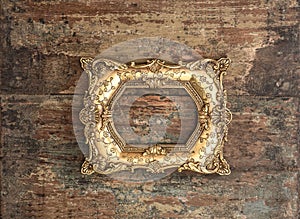 Antique golden frame on used wooden background. Rustic texture