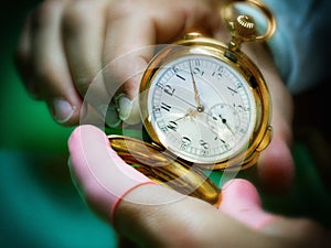 Antique golden pocket watch with clockmaker fingers