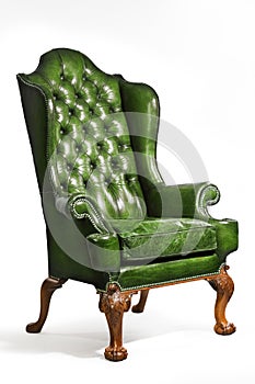 Antique green leather wing chair carved legs isolated