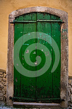antique green wooden door closed with a bolt