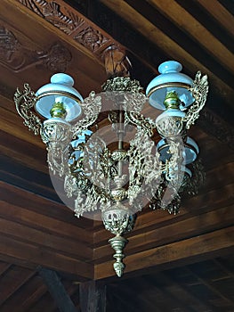 Antique hanging lamp, with carved wooden background