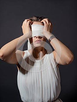 An antique heroine blindfolded, a young woman in a tunic with a blindfold,