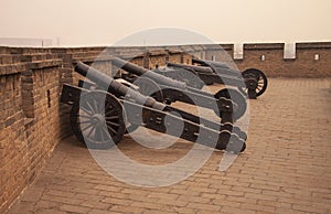 Antique iron cannons at the last remaining intact Ming Dynasty city wall in China the Chinese city Pingyao, Shanxi Province. Old c