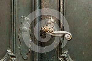 antique iron handle on the background of wooden door