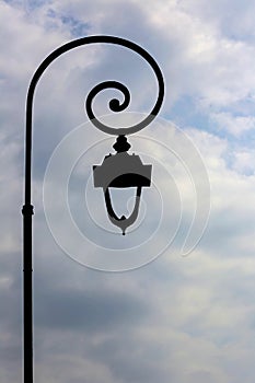 Antique lamp post with clouds background