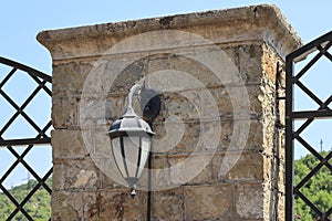 Antique lantern on a cracked brick wall