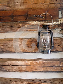 Antique Lantern Hanging on a Log Cabin Wall