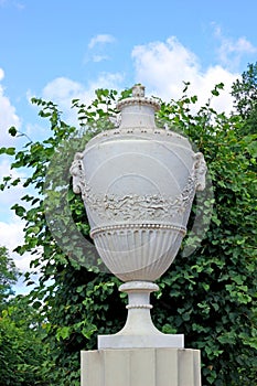 Antique marble amphora on a stone pedestal in the park