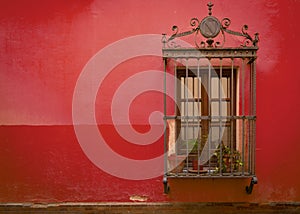 Antique medieval window with rusty iron bars and Red Pear wall