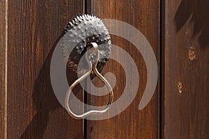 Antique metal door handle on a rough wooden background. Close-up