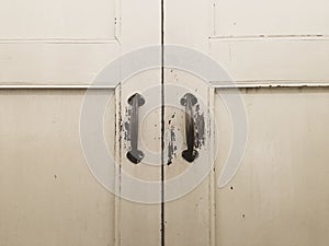 Antique metal door handles on the old wooden door.