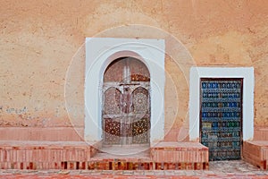 Antique Moroccan doors against old orange pink wall.