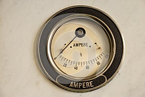 An antique non-functioning ammeter hangs on the wall as an element of decor