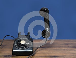 Antique old rotary dial telephone on wooden desk