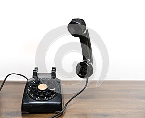 Antique old rotary dial telephone on wooden desk