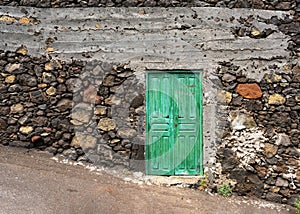 Antique old weathered dark green wooden door of old house. Facade detail, doors and windows.