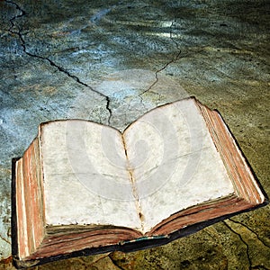 Antique open book on cracked surface