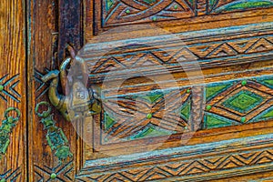 An antique padlock in the shape of a one-humped dromedary camel guards the tranquility on a beautifully decorated door