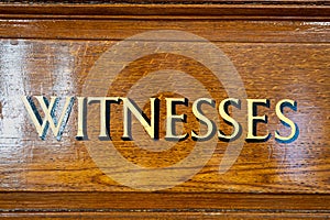 An antique painted door sign of wording in capital letters, showing where witnesses should enter.