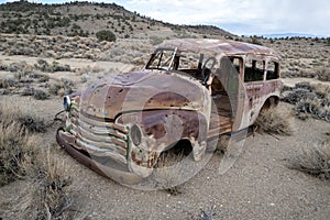 An antique panel truck rusts near an abandoned mine in the Nevada desert, USA photo