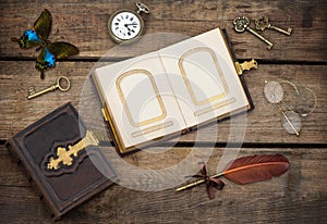 Antique photo album with butterfly over wooden background