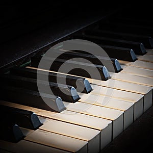 Antique piano keyboard fading into a black background with copy