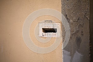 Antique plastered wall with a hole for mail letters. pretura lettere, inscription near the hole photo