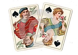 Antique playing cards showing a jack and queen of spades.