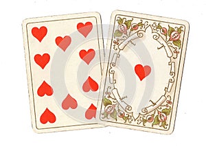 Antique playing cards showing a ten and ace of hearts.