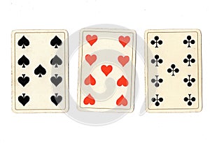 Antique playing cards showing three nines.