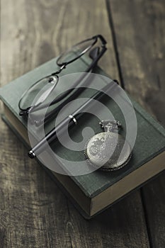 Antique pocket watch, glasses and book