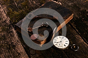 Antique pocket watch, old book with ancient copper coins