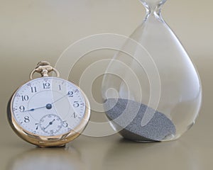 Antique pocket watch with an old hour glass used for telling time