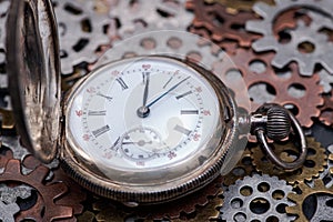 Antique pocket watch and old vintage hour metallic gears on natural stone