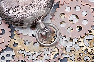 Antique pocket watch and old vintage hour metallic gears on natural stone