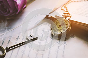 Antique pocket watch and old vintage key with vintage tone