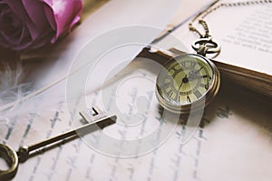 Antique pocket watch and old vintage key with vintage tone