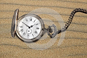 Antique pocket watch on sand