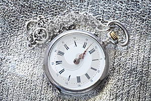 antique pocket watch on silver fabric background