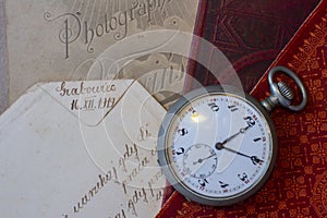 Antique pocket watch with Victorian items. Old books and photographs. Vintage theme background