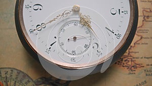 Antique pocket watch with white dial and gold moving second, minute and hour hands. Pocketwatch against background of an