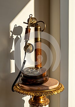 Antique polished wood candlestick telephone on marble table