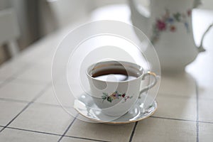 antique porcelain tea set on white background. cup of tea and a kettle on a table