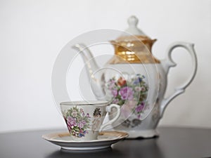 Antique porcelain teapot with cup and saucer